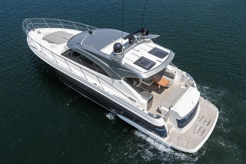 Slide: The Image of 2021 Riviera 4800 Sport Yacht cruising on open water, showcasing sleek design and spacious deck. - 7