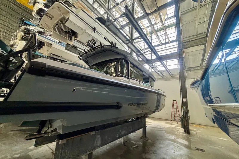 Slide: The Image of 2024 Axopar 37 XC Cross Cabin boat hull in a workshop setting. - 10