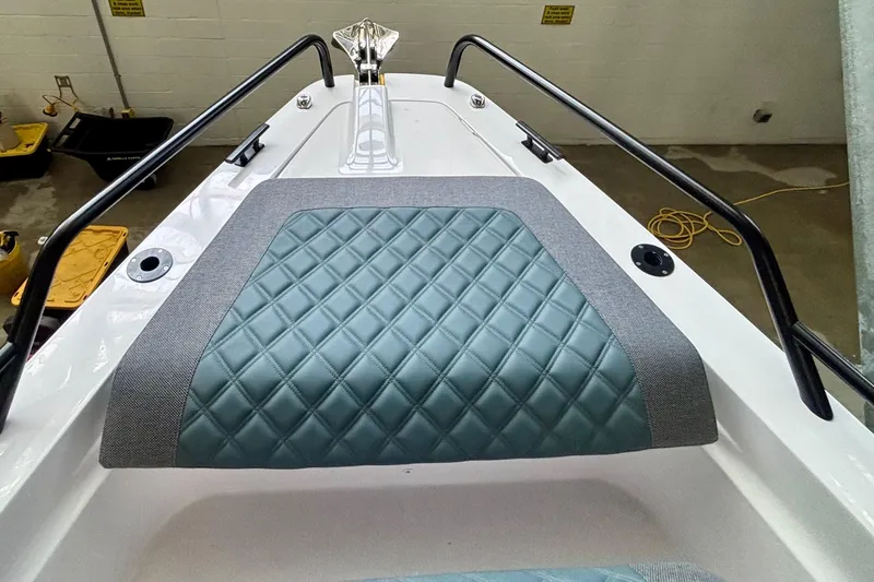 Slide: The Image of 2024 Axopar 37 XC Cross Cabin with blue quilted seating in a showroom. - 16