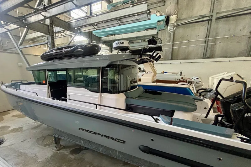 Slide: The Image of 2024 Axopar 37 XC Cross Cabin boat in storage facility, side view. - 2