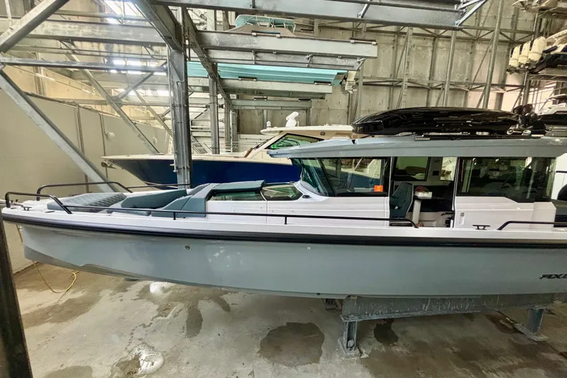 Slide: The Image of 2024 Axopar 37 XC Cross Cabin with dual outboard engines in a boatyard. - 4