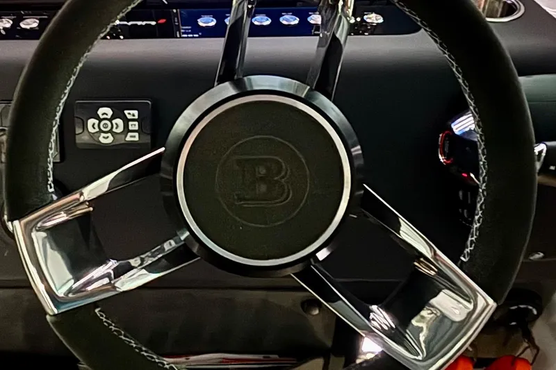 Slide: The Image of 2024 Axopar 37 XC Cross Cabin helm with steering wheel and control panel. - 46