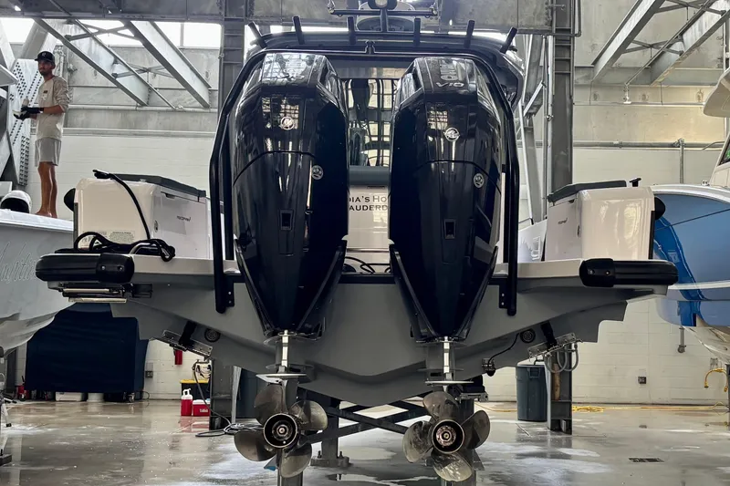 Slide: The Image of 2024 Axopar 37 XC Cross Cabin with dual outboard engines in a boatyard. - 5