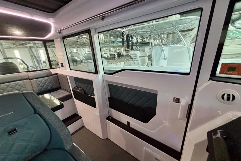 Slide: The Image of 2024 Axopar 37 XC Cross Cabin interior with quilted seating and panoramic windows. - 54