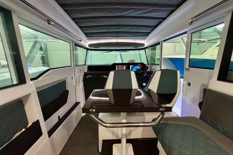 Slide: The Image of 2024 Axopar 37 XC Cross Cabin interior with elegant seating and polished table. - 57