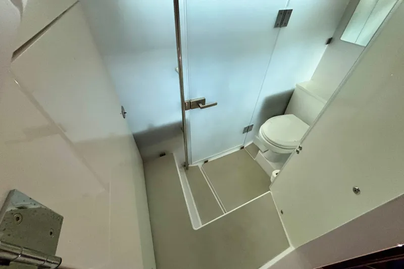 Slide: The Image of 2024 Axopar 37 XC Cross Cabin bathroom with toilet, mirror, and storage. - 60