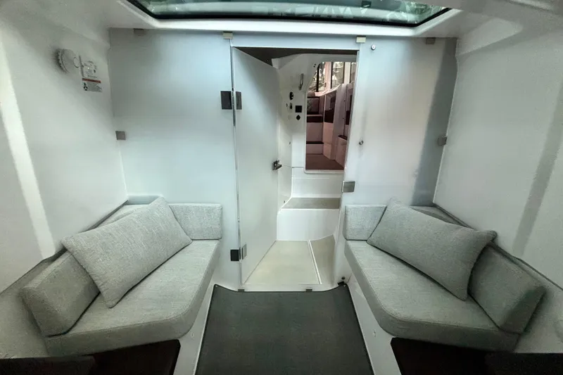 Slide: The Image of 2024 Axopar 37 XC Cross Cabin interior with gray seating and foldable table. - 66
