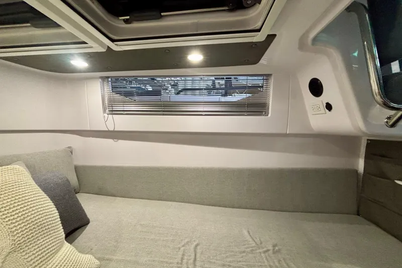 Slide: The Image of 2024 Axopar 37 XC Cross Cabin interior with cozy seating and window blinds. - 75