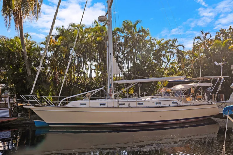 Slide: The Image of 2006 Island Packet 440 sailboat docked near lush tropical trees. - 1