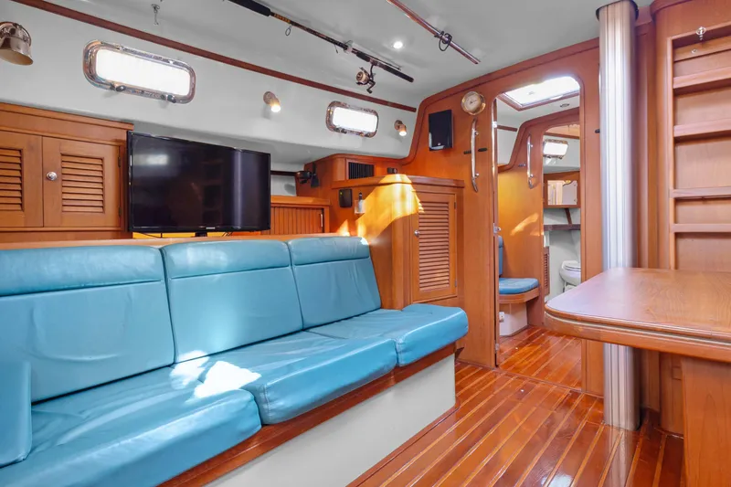 Slide: The Image of Interior of 2006 Island Packet 440 yacht with blue seating and wooden finishes. - 19