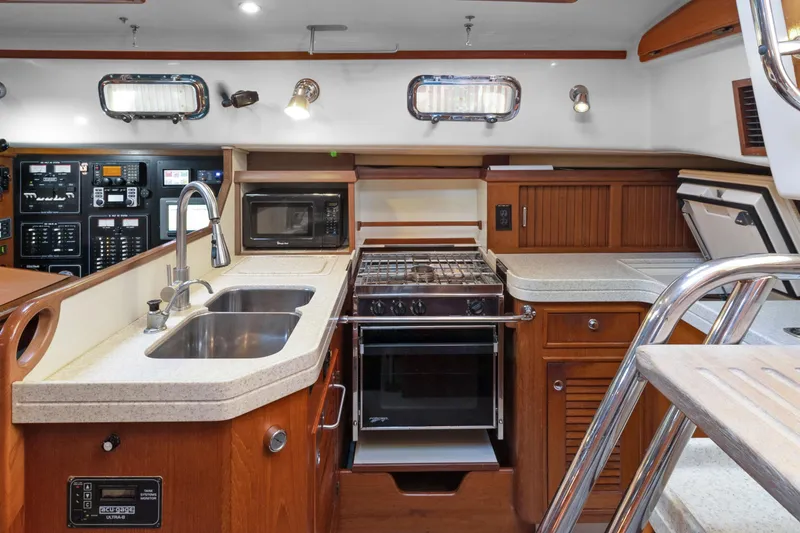 Slide: The Image of Luxurious 2006 Island Packet 440 yacht kitchen with modern appliances and elegant wood cabinetry. - 22