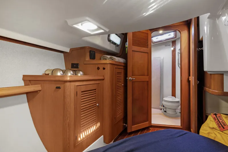 Slide: The Image of 2006 Island Packet 440 yacht interior with wooden cabinetry and bathroom view. - 27