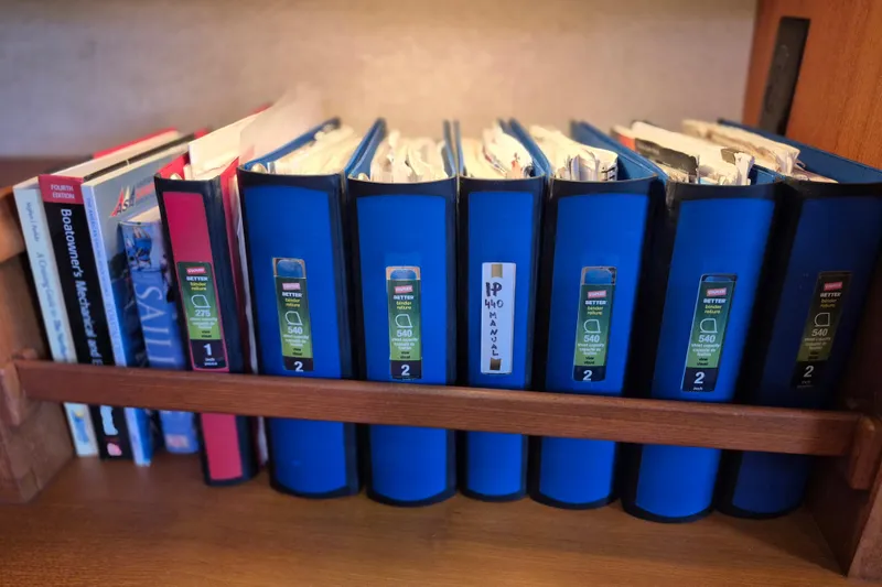 Slide: The Image of Books and binders on a shelf, including Island Packet 440 manual, 2006 model. - 37