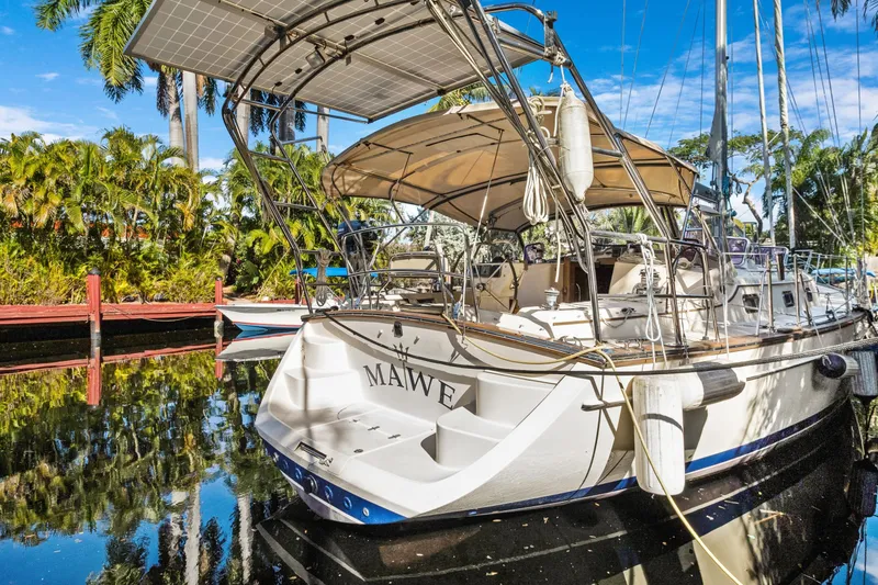 Slide: The Image of 2006 Island Packet 440 sailboat docked, featuring solar panels and lush tropical surroundings. - 4
