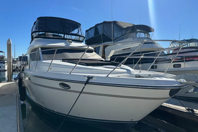 The Image of 2000 Maxum 4600 SCB yacht docked at marina under clear blue sky. - 0