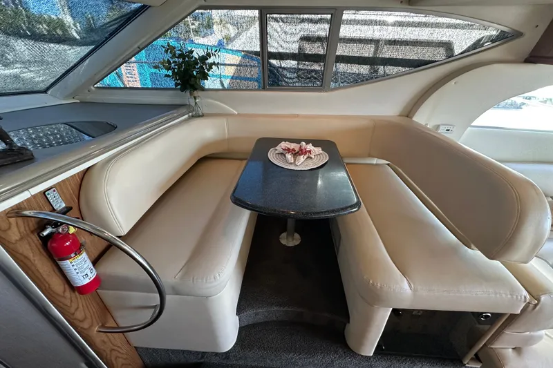 Slide: The Image of Interior of 2000 Maxum 4600 SCB yacht with cream seating and black table. - 11