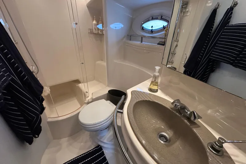 Slide: The Image of Bathroom interior of 2000 Maxum 4600 SCB yacht with shower, sink, and porthole window. - 19