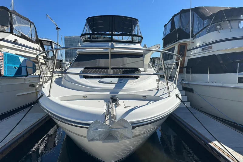 Slide: The Image of 2000 Maxum 4600 SCB yacht docked between two boats in a marina. - 2