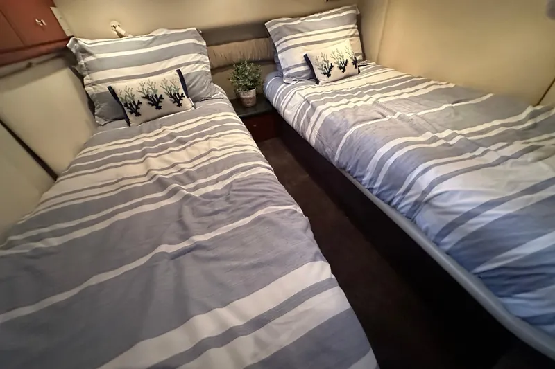 Slide: The Image of Twin beds with striped bedding in a 2000 Maxum 4600 SCB yacht cabin. - 21