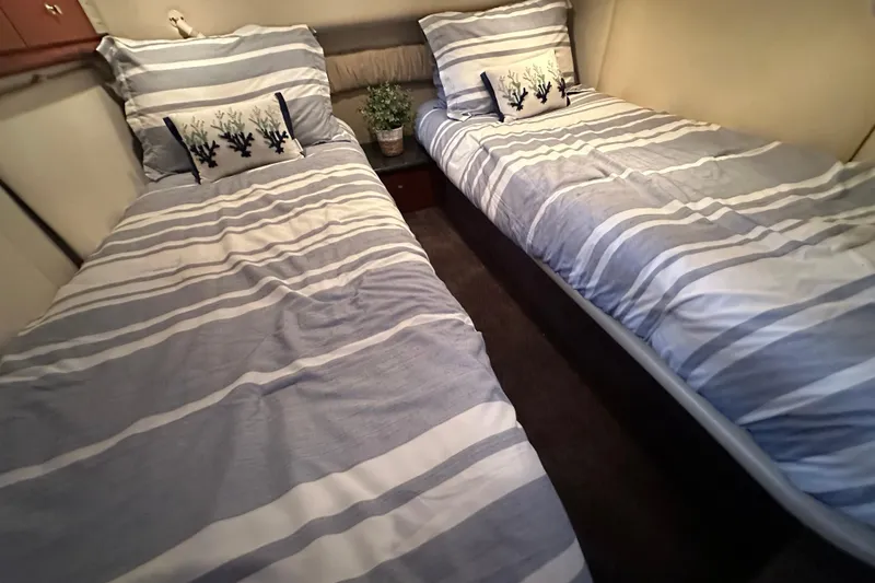 Slide: The Image of Twin beds with striped bedding in a 2000 Maxum 4600 SCB yacht cabin. - 22