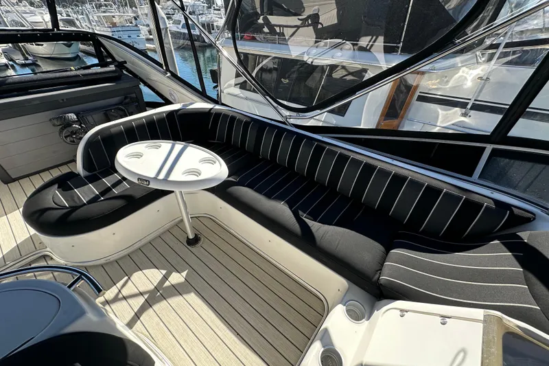 Slide: The Image of Luxurious seating area on a 2000 Maxum 4600 SCB yacht with striped cushions and table. - 29