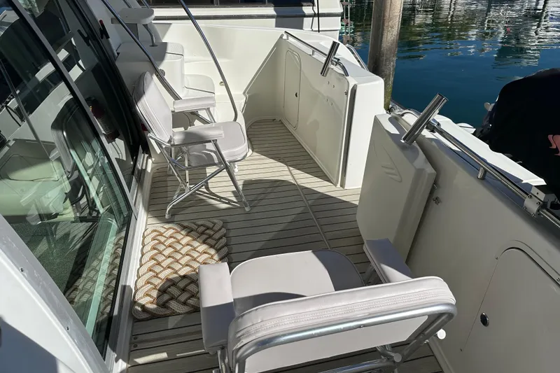 Slide: The Image of Deck area of 2000 Maxum 4600 SCB yacht with chairs and water view. - 4