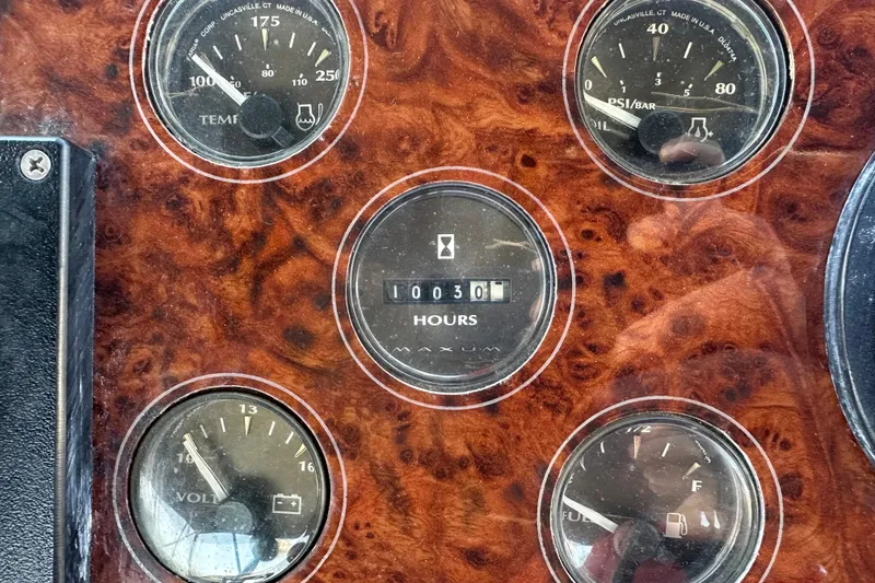 Slide: The Image of Dashboard gauges of a 2000 Maxum 4600 SCB boat, showing engine hours and fuel levels. - 56