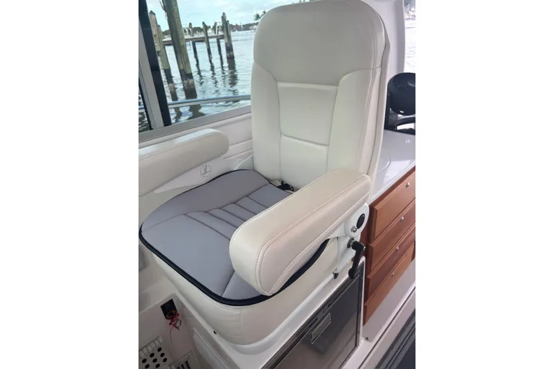 Slide: The Image of Captain's chair on 2019 Back Cove 34O boat, featuring white upholstery and armrests. - 17