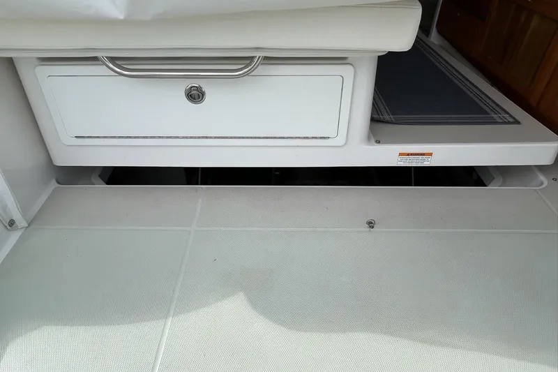 Slide: The Image of 2019 Back Cove 34O interior storage compartment with white cushioned seating. - 22