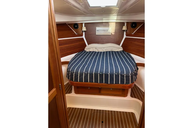 Slide: The Image of 2019 Back Cove 34O cabin with striped bedding and wooden interior. - 25