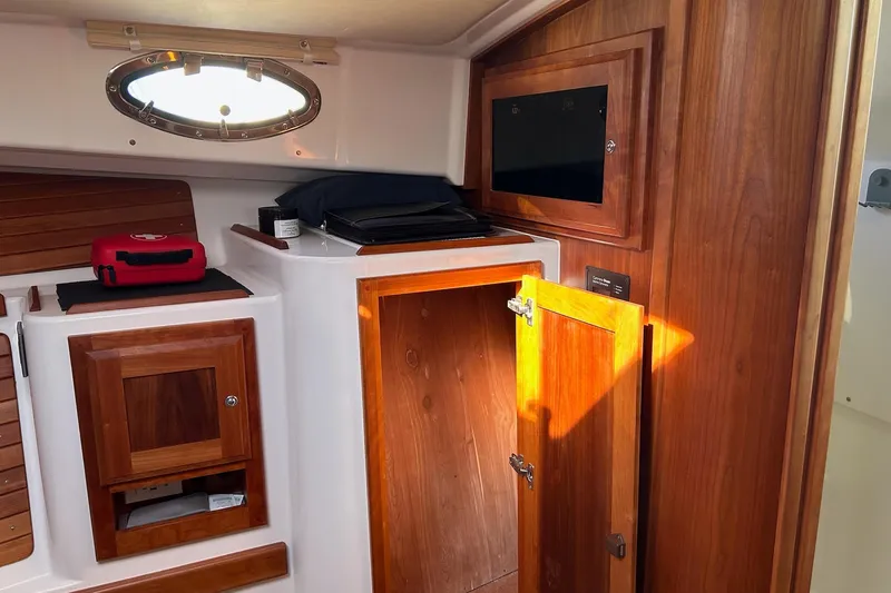 Slide: The Image of Interior of 2019 Back Cove 34O boat with wooden cabinetry and storage compartments. - 27