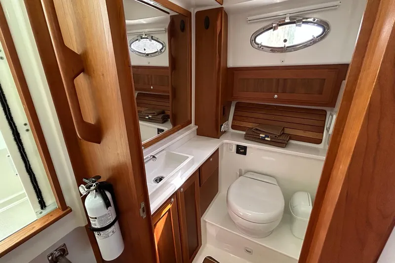Slide: The Image of 2019 Back Cove 34O yacht bathroom with wooden cabinetry, sink, and toilet. - 28