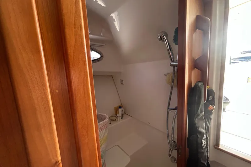 Slide: The Image of 2019 Back Cove 34O boat interior shower with wooden door and porthole window. - 29
