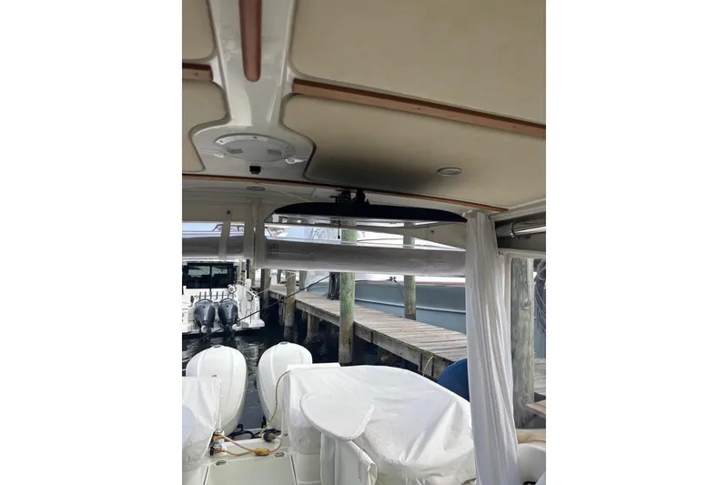 Slide: The Image of 2019 Back Cove 34O boat interior with dock view and covered outboard engines. - 9