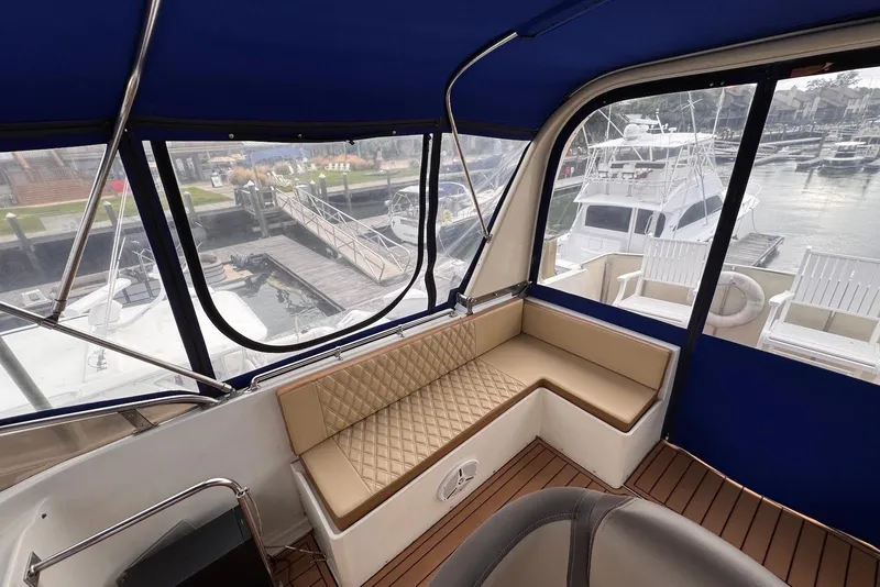 Slide: The Image of Interior view of 1988 Jefferson 52 Monticello yacht with blue canopy and beige seating. - 16