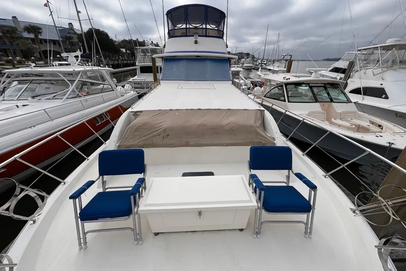 Slide: The Image of 1988 Jefferson 52 Monticello yacht docked, featuring blue chairs and a white table on deck. - 21