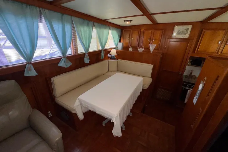 Slide: The Image of Interior of 1988 Jefferson 52 Monticello yacht with cozy dining area and blue curtains. - 37