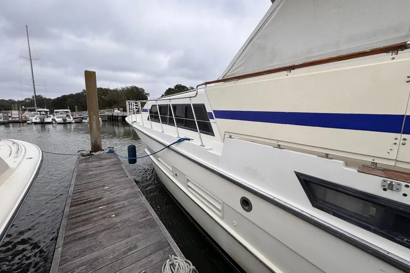 Slide: The Image of 1988 Jefferson 52 Monticello yacht docked at marina, overcast sky, wooden pier. - 4
