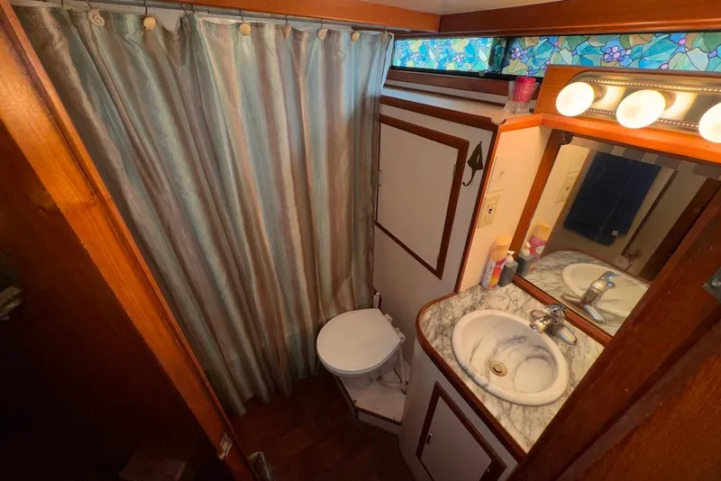 Slide: The Image of Compact bathroom in 1988 Jefferson 52 Monticello boat with marble sink and shower curtain. - 48