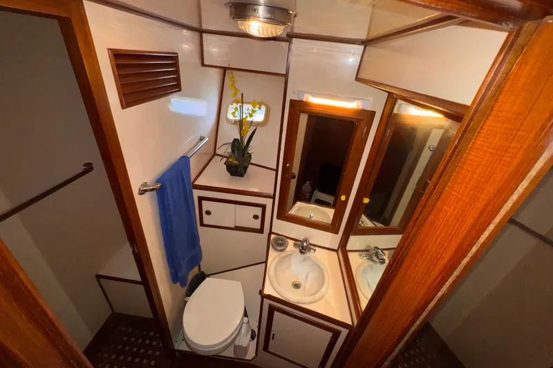 Slide: The Image of Compact bathroom in 1988 Jefferson 52 Monticello yacht with sink, toilet, and mirror. - 56