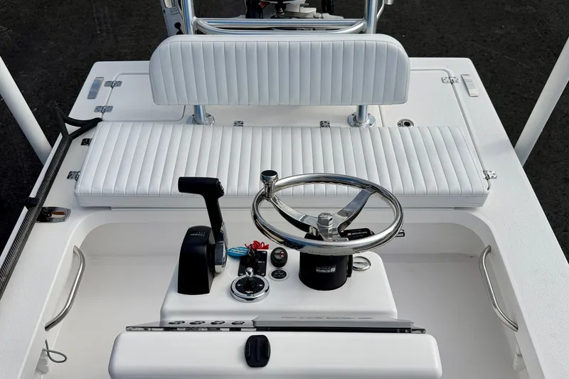 Slide: The Image of 2024 Outlaw Legend 17 boat interior with steering wheel and white seating. - 13