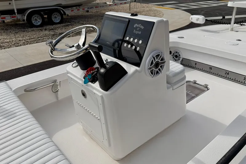 Slide: The Image of 2024 Outlaw Legend 17 boat console with steering wheel and control panel. - 15