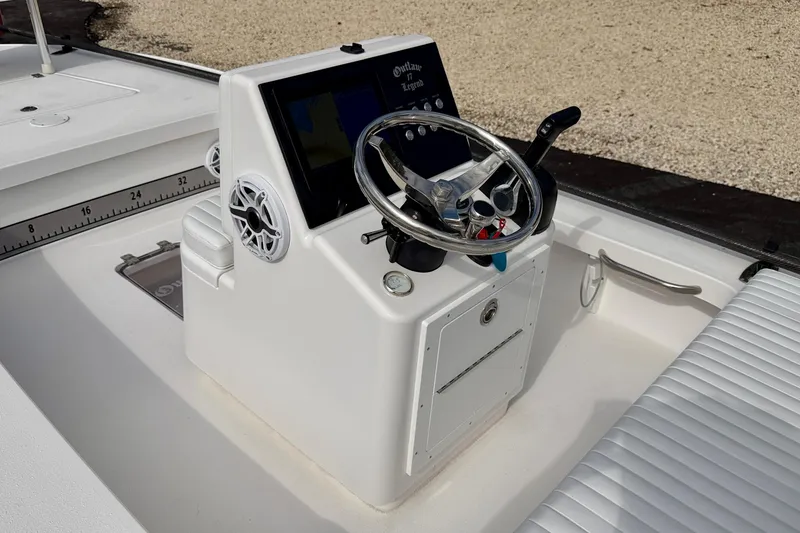 Slide: The Image of 2024 Outlaw Legend 17 boat console with steering wheel and controls. - 16