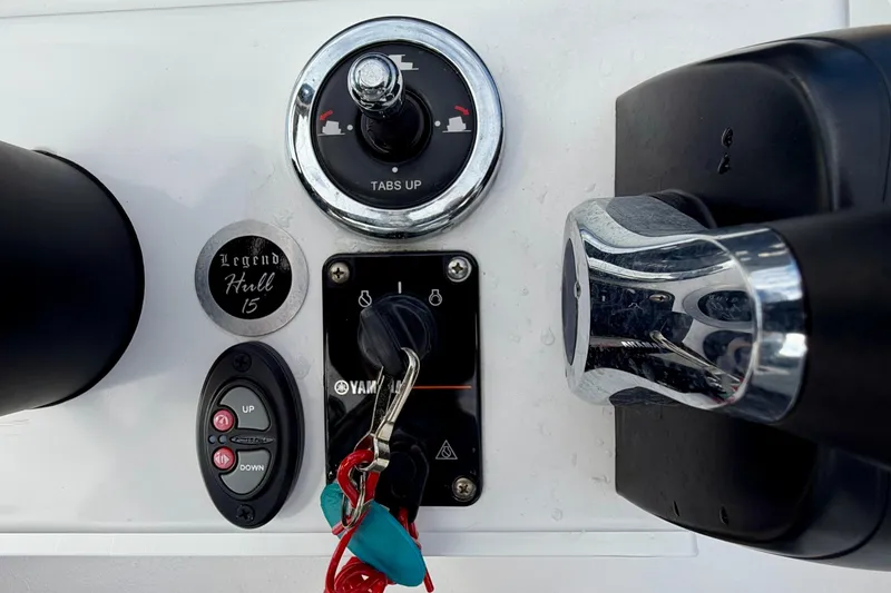 Slide: The Image of 2024 Outlaw Legend 17 boat controls with ignition, throttle, and trim tabs. - 21