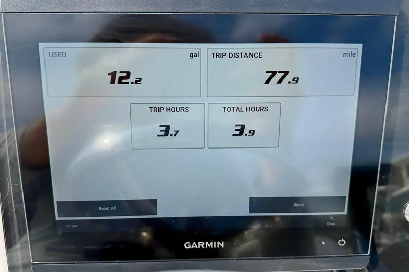 Slide: The Image of Garmin display showing trip data: 12.2 gallons used, 77.9 miles traveled, 2024 Outlaw Legend 17. - 23