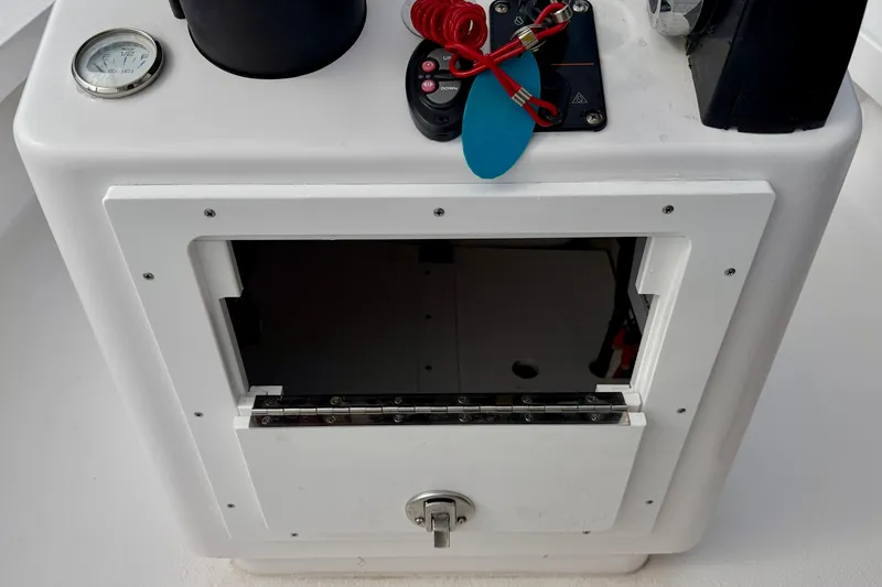 Slide: The Image of 2024 Outlaw Legend 17 boat console with controls and storage compartment. - 27