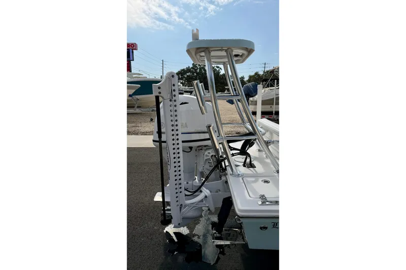 Slide: The Image of 2024 Outlaw Legend 17 boat with Yamaha motor, docked outdoors under clear sky. - 32