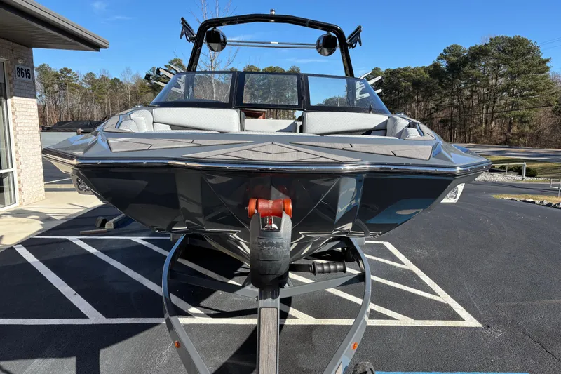 Slide: The Image of 2023 Supreme ZS232 boat on trailer in parking lot, clear sky background. - 2