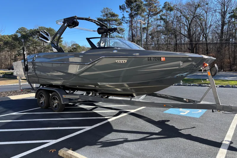 Slide: The Image of 2023 Supreme ZS232 boat on trailer in parking lot, surrounded by trees. - 3