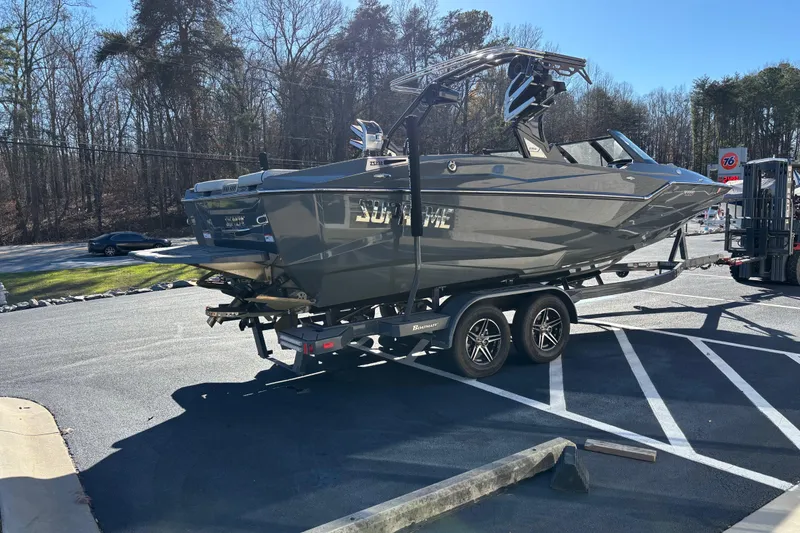Slide: The Image of 2023 Supreme ZS232 boat on trailer in parking lot, surrounded by trees. - 4